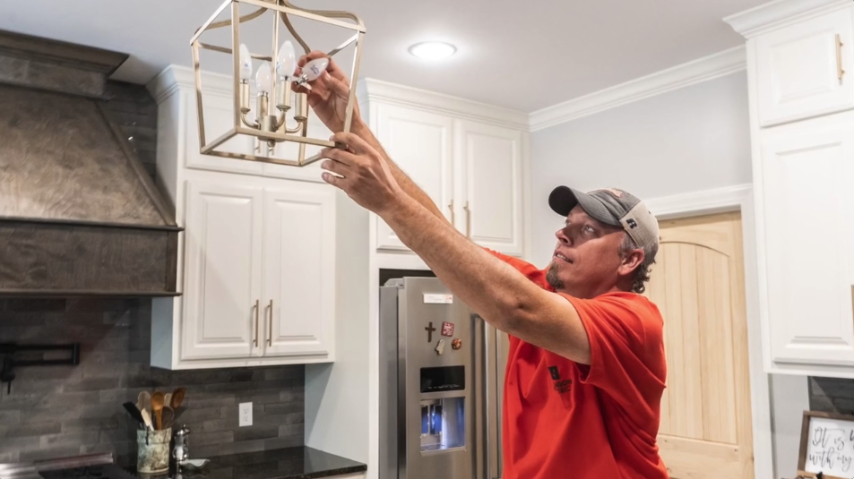 Electrician changing light fixture